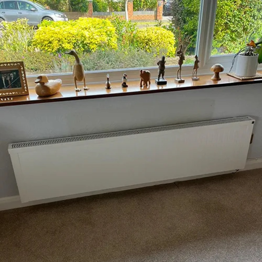 A NEOS electric radiator installed in a bedroom